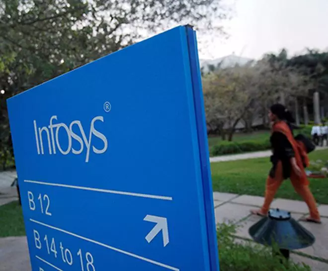 FILE PHOTO: An employee walks past a signage board in the Infosys campus at the Electronics City IT district in Bangalore, February 28, 2012. REUTERS/Vivek Prakash/File Photo