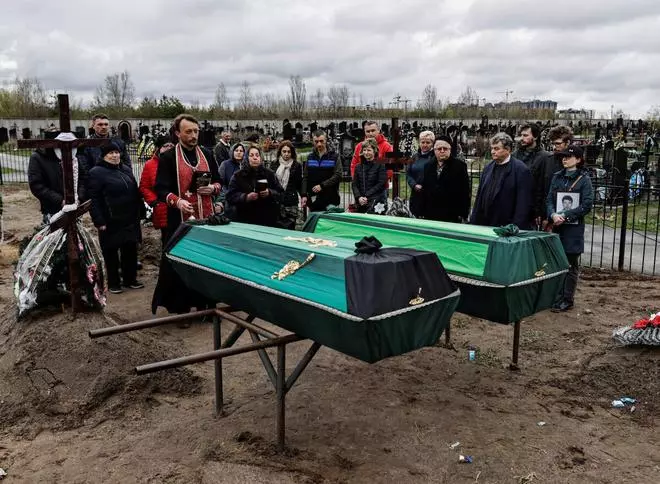 Relatives attend the funeral service of Anatolii Strilec, 68, who according to his family was killed by Russian soldiers while he was preparing food outside his building, and Fedorovskyi Dnytro, 51, before their burial, amid Russia’s invasion of Ukraine, at the cemetery in Bucha, Kyiv region, Ukraine April 26, 2022. 