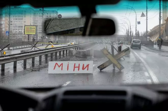 A sign in Ukrainian which reads “Mine” is seen at a road block as Russia’s invasion of Ukraine continues, in Kyiv
