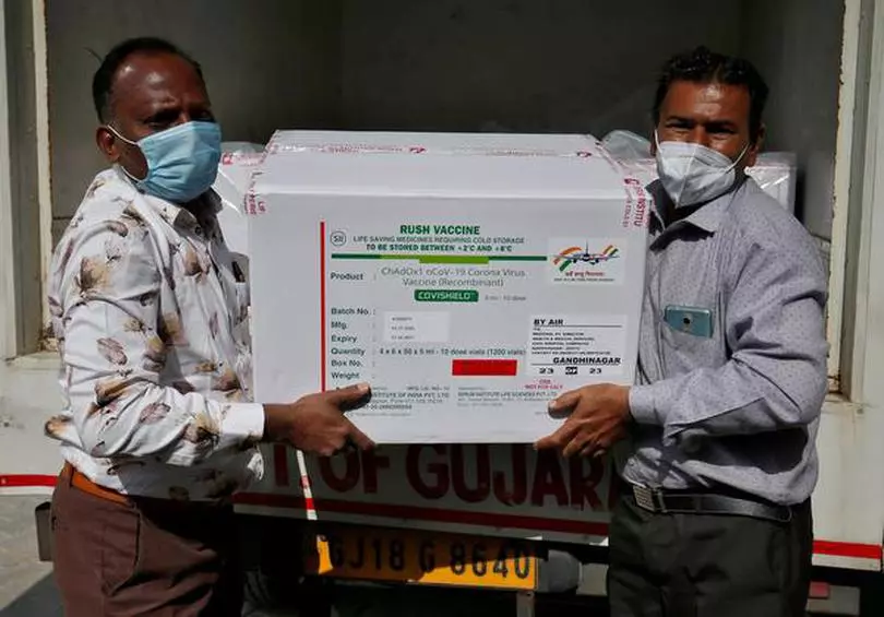 FILE PHOTO: Officials unload boxes containing vials of AstraZeneca's COVISHIELD, a coronavirus disease (COVID-19) vaccine manufactured by Serum Institute of India, outside a vaccination storage centre in Ahmedabad